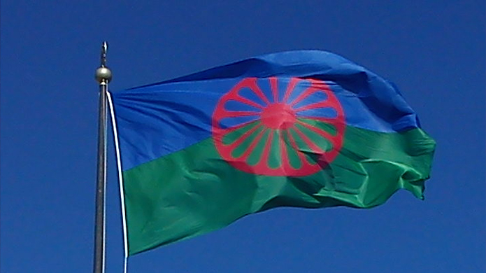 Romska flaggan mot blå himmel 