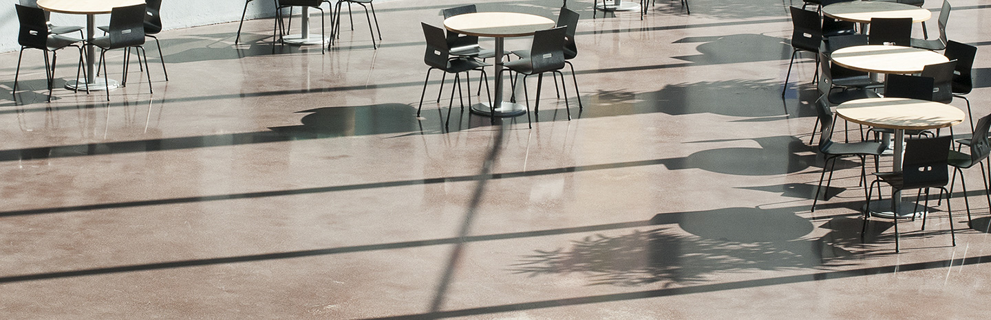 Stolar och runda bord på golv med ljusstrålar