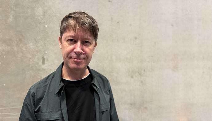 Porträttbild Joakim Ekman framför betongvägg