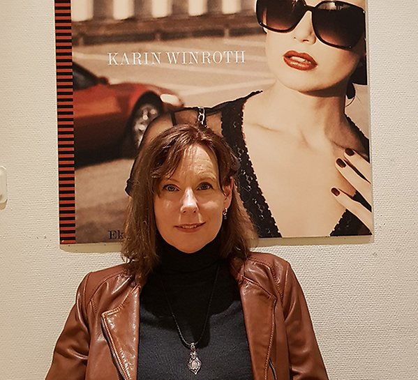 Karin Winroth framför omslaget till sin bok Fashionabla varumärken.  Foto: Ekerlids Förlag (Creative Commonce license)